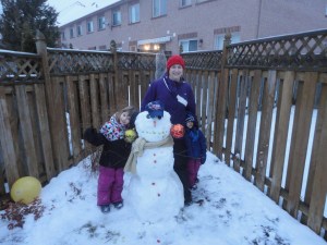 Melissa, Abby & Aiden posing with the family snowman