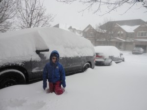 Aiden standing in front of the van and car