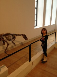 Abby looking at a small dinosaur that was tucked away down a hall