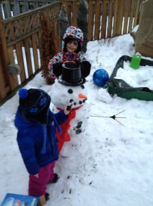 Abby & Aiden putting the hat and mouth on the dinosaur