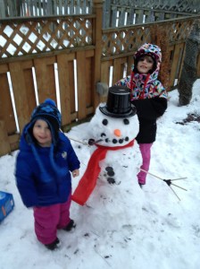 Aiden & Abby posing beside their snowman