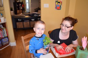 Aiden holding the plant that he gave tom Mom for Mother's Day