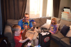 Peter holding up gift from Aiden while Abby looks on