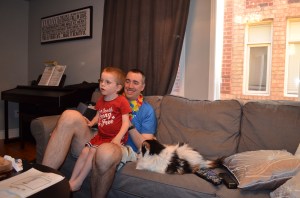 Aiden sitting on Peter's lap listening to Abby's poem.