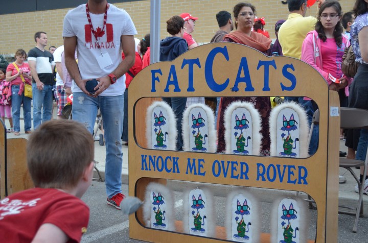 Aiden throwing bean bags at FatCats carnival game.