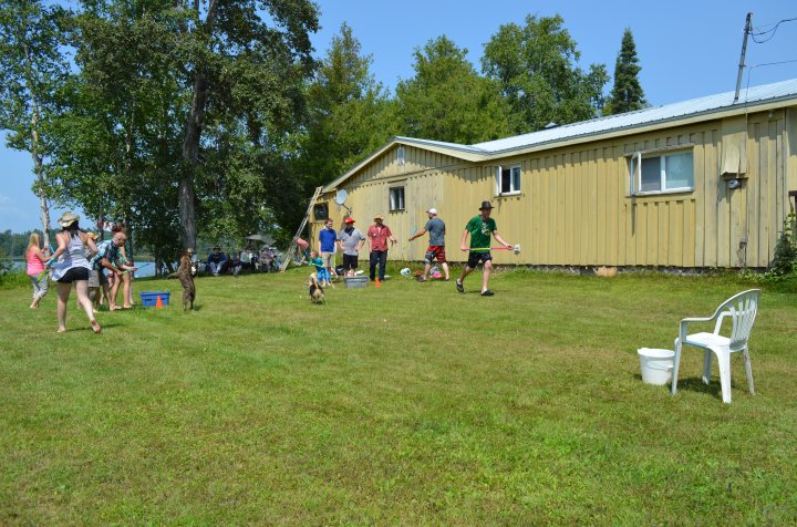 Lila jumping up to catch the water as people spray each other back and forth