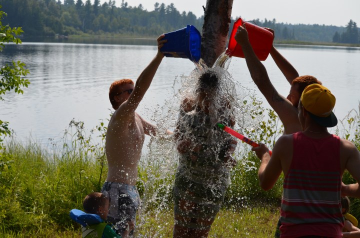 Lucas, Philip and Jordan dumping water onto Stephanie G. who is taped to the tree.