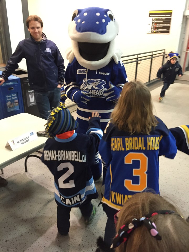 Aiden and Abby high-fiving Sauga at PCHA Coaches night.
