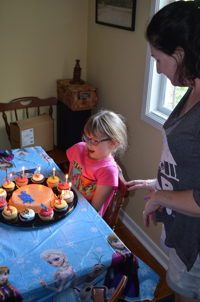 Abby blowing out the candles on her cupcakes